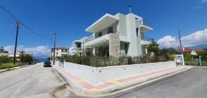 a white house on the side of a street at Villa Demiris at Vrachneika Beach in Flámbouras