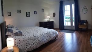 a bedroom with a bed and a sliding glass door at LE CLOS DES PRAIRIES Suite 2 grandes chambres in Saint-Yan +12 photos