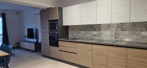 a large kitchen with wooden cabinets and a television at Sea Breeze Penthouse and Terrace Qawra St Paul's Bay in St Paul's Bay