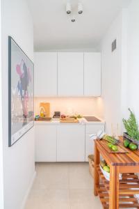a kitchen with white cabinets and a wooden table at The Old Town View Apartment in Warsaw