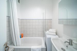 a white bathroom with a tub and a sink at The Old Town View Apartment in Warsaw