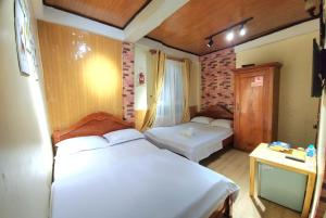a bedroom with two beds and a table with a desk at Bình Đào Hotel - Khách sạn ngay trung tâm giá rẻ in Da Lat