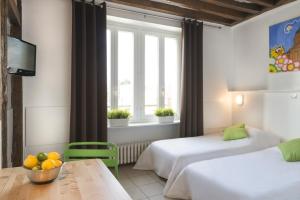 una camera d'albergo con due letti e un tavolo con un cesto di frutta di Résidence Chlorophylle ad Arcueil