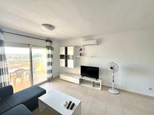 een woonkamer met een blauwe bank en een tv bij Apartamento a pie de Playa NTRLL in La Venteta