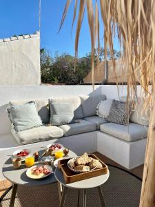 a living room with a couch and a table with food on it at Casita 10 Málaga, holiday home with roof terrace in Málaga