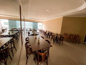a restaurant with tables and chairs in a room at Hotel Cantinho Verde in Teixeira de Freitas