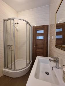uma casa de banho com um chuveiro e um lavatório branco em Vila BonBon 3 em Biograd na Moru