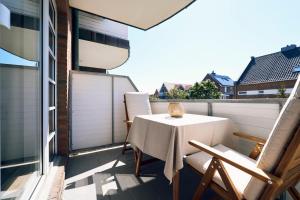 a balcony with a table and chairs on a balcony at Haus am Nordstrand in Norderney