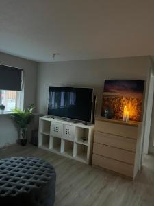 a living room with a flat screen tv on a white cabinet at Family apartment in Reykjavík