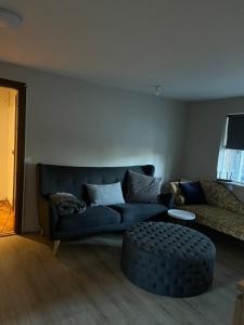 a living room with a blue couch and a table at Family apartment in Reykjavík