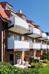an apartment building with white balconies and a patio at Haus am Nordstrand in Norderney