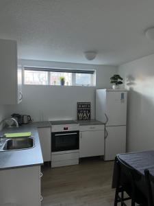 a kitchen with a white refrigerator and a table at Family apartment in Reykjavík