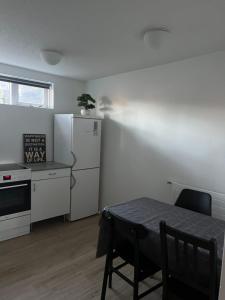 a kitchen with a table and a white refrigerator at Family apartment in Reykjavík +3 photos