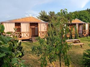 a group of wooden huts in a yard at słoneczny domek II in Kołczewo