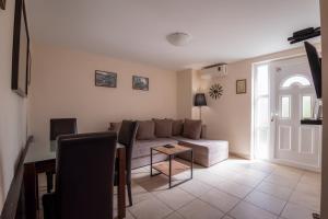 ein Wohnzimmer mit einem Sofa und einem Tisch in der Unterkunft Apartmani Bijelic HN in Herceg-Novi