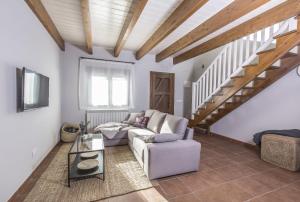 Una sala de estar con un sofá y una escalera. en Senda del Cabrerizo, en Albarracín