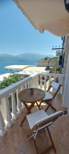 uma mesa e cadeiras numa varanda com o oceano em La casa di Sonja em Tivat