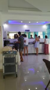 un grupo de personas esperando en un mostrador del hospital en Altunakar 1 Hotel, en Didim