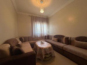 a living room with a couch and a table at Appartement à Houma, proche Port Tanger Med in Dalia