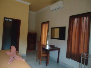 um quarto com uma secretária, uma cama e um espelho em Kenari Diwang em Ubud