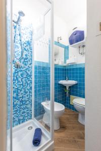 baño de azulejos azules con 2 aseos y ducha en Speranza Apartment BBQ e Parcheggio Privato, en Valverde