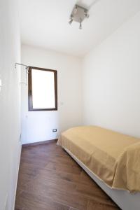 um quarto branco com uma cama e uma janela em Speranza Apartment BBQ e Parcheggio Privato em Valverde
