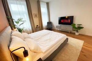 メンヒェングラートバッハにあるModernes City-Apartment in MönchengladbachのベッドとNetflixの文字が書かれたテレビのある寝室