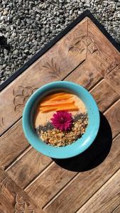 a blue bowl of soup with a pink flower in it at Bell Glamping by The Hulya Mukteshwar in Mukteshwar