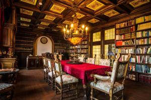 een bibliotheek met een tafel met stoelen en een kroonluchter bij Hotel Schloss Grochwitz (garni) in Herzberg