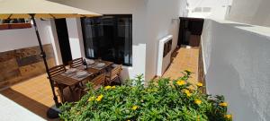 einen Balkon mit einem Tisch und einem Sonnenschirm in der Unterkunft Casa Remo in Playa Honda