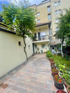 a walkway in front of a building with potted plants at Convini Bed & Bathroom Homestay in Pristina