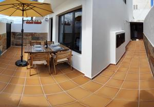 ein Esszimmer mit einem Tisch und einem Sonnenschirm auf dem Boden in der Unterkunft Casa Remo in Playa Honda + 45 Fotos