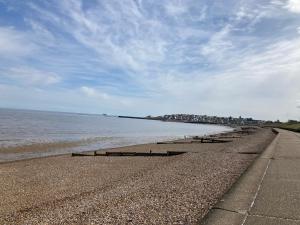 a row of benches on a beach next to the water at Seaview Holiday Rentals - Seawall in Whitstable