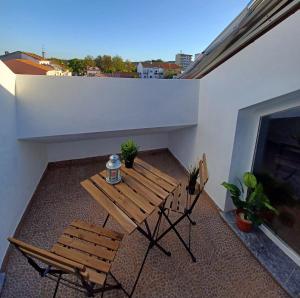 een houten tafel en stoelen op een balkon met een open haard bij AL Encanto in Grândola