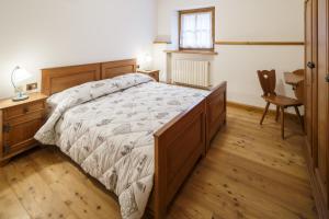 a bedroom with a bed and a dresser at Villa Lacedel - Stayincortina in Cortina dʼAmpezzo