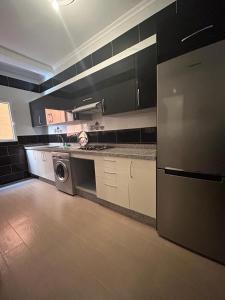 a kitchen with white cabinets and a washer and dryer at Appartement à Houma, proche Port Tanger Med in Dalia
