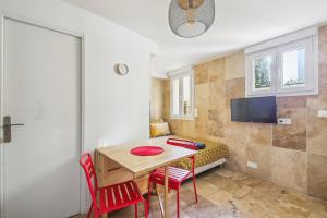 モントルイユにあるTop Appartement avec Wifi - Proche Paris & Métro - R6のテーブルと椅子とテレビのある部屋