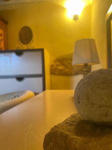 een tafel met een lamp en een rots erop bij Pienzalettings "Suites" in Pienza