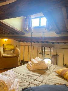 ein Schlafzimmer mit einem Bett und einem Stuhl mit Handtüchern darauf in der Unterkunft Pienzalettings "Suites" in Pienza