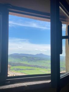 een raam met uitzicht op een groen veld bij Pienzalettings "Suites" in Pienza
