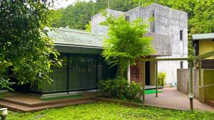 uma vista exterior de uma casa com uma árvore em Minami Hakone Villa em Kannami