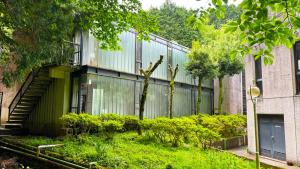 um edifício verde com uma escada em frente em Minami Hakone Villa em Kannami