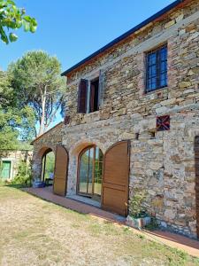 un edificio de piedra con dos puertas de garaje. en Il Casolare del Pastore en Suvereto