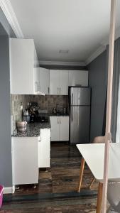 a kitchen with white cabinets and a stainless steel refrigerator at Tatas Place in Batumi