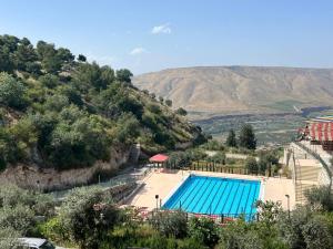 a large swimming pool with a mountain in the background at منتجع وفندق جدارا Jadara Resort & Hotel in Um Qeis