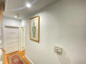 un pasillo con una foto en una pared blanca en Gorgeous Refurbished 1Bdrm and 1Den Home, en Washington