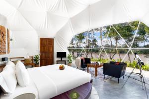 1 dormitorio con 1 cama en una tienda blanca en Bansaeo Garden and Resort, en Chiang Saen