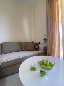 a living room with a white table and a couch at Cottage Oasis in Hanioti