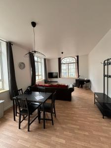 a living room with a table and a couch at Le 12 T2 cosy wifi parking gratuit st Victor in Saint-Étienne