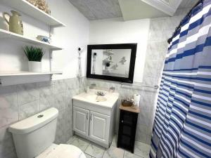 y baño con aseo blanco y lavamanos. en Private Suite next to Calle Ocho - 2V, en Miami